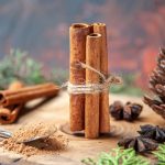 front-view-cinnamon-sticks-cinnamon-powders-pinecone-anises-wood-board-dark